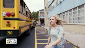 West Virginia student in front of yellow bus
