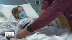 nurse helping female patient in hospital bed