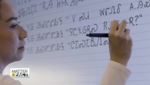 Cherokee woman at the white board writing sentences