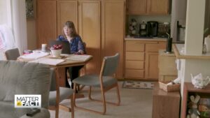 woman sitting at table in front of laptop